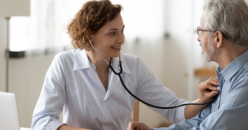 Doctor using using stethoscope to check patient heartbeat